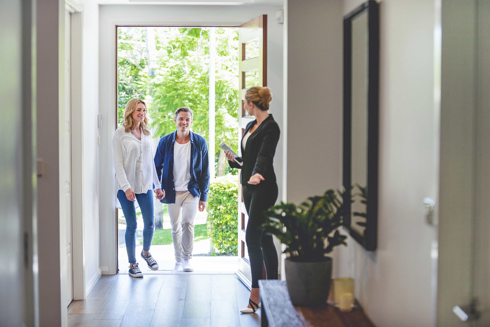 Real estate agent welcoming people into house